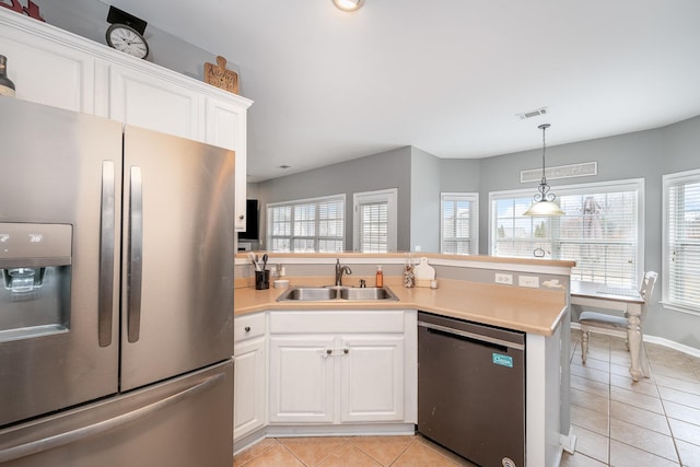 kitchen with dishwashing machine, a wealth of natural light, sink, white cabinetry, and stainless steel fridge with ice dispenser