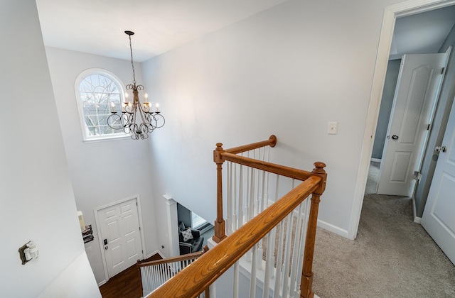 stairs featuring carpet flooring and a chandelier