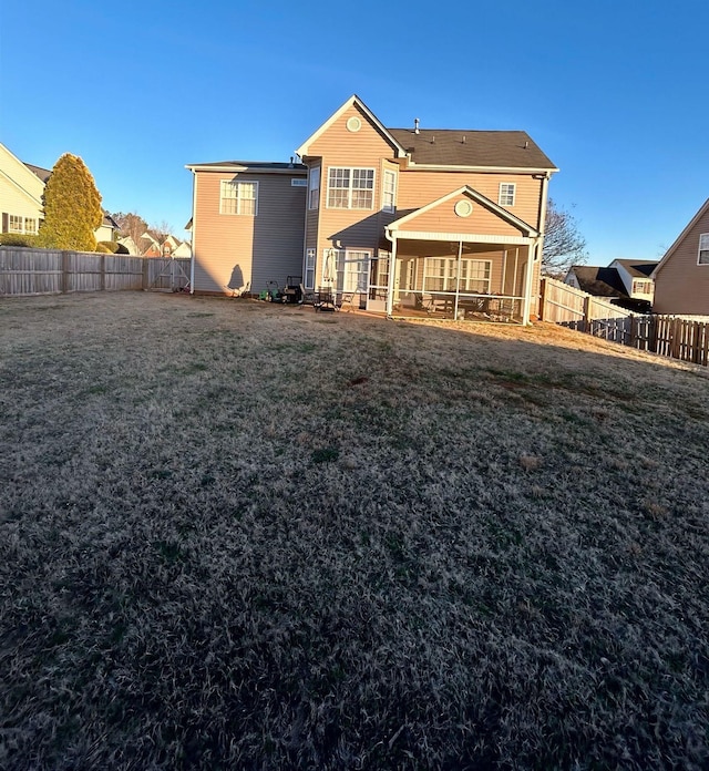 rear view of house featuring a yard
