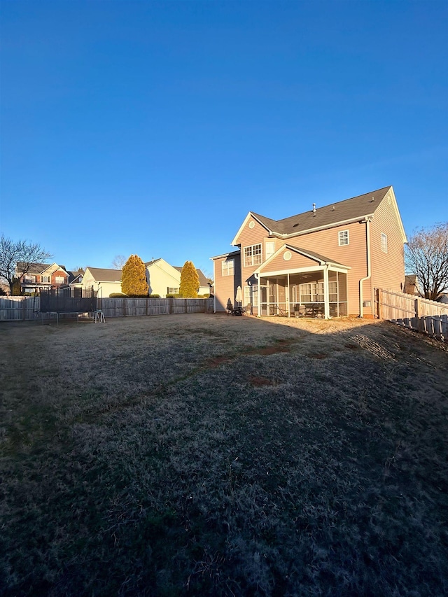 view of yard featuring a trampoline and a sunroom