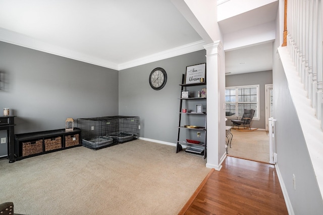 sitting room with ornamental molding, carpet flooring, and decorative columns
