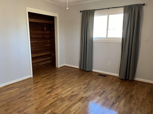 spare room featuring dark hardwood / wood-style floors and ornamental molding