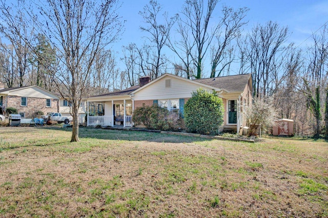 single story home featuring covered porch and a front yard