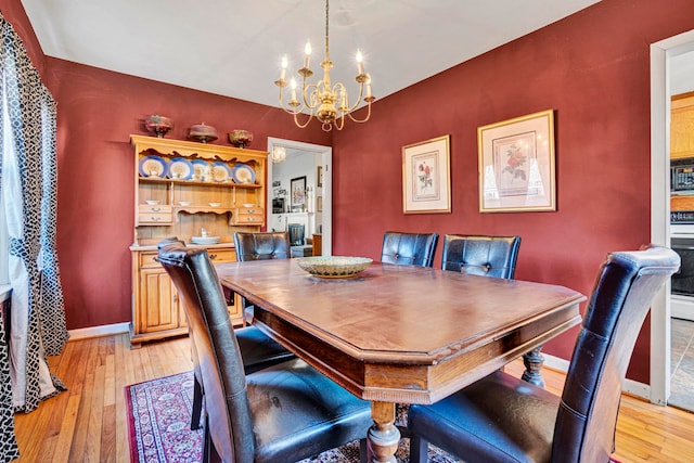 dining room featuring light hardwood / wood-style floors and a notable chandelier