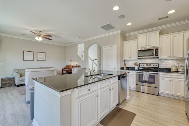 kitchen with a center island with sink, white cabinetry, appliances with stainless steel finishes, and sink