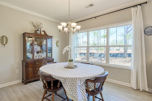 dining area featuring light hardwood / wood-style floors, an inviting chandelier, and crown molding