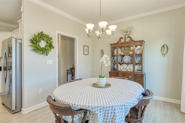 dining room featuring crown molding, a chandelier, and light hardwood / wood-style flooring