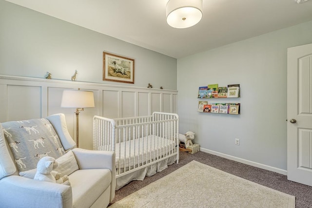 carpeted bedroom featuring a nursery area