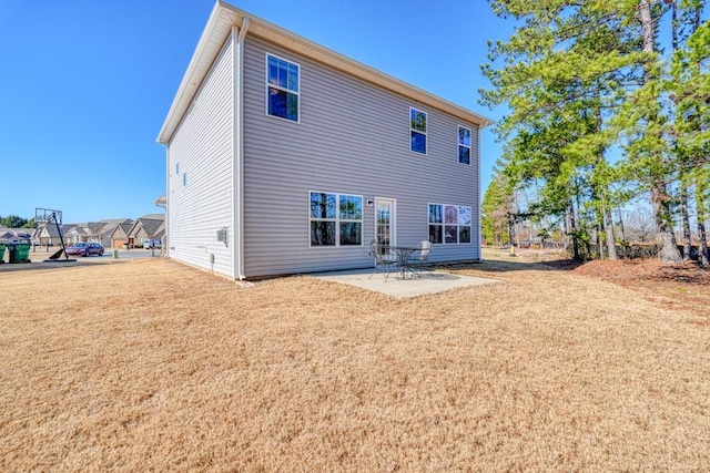 back of property with a patio and a yard