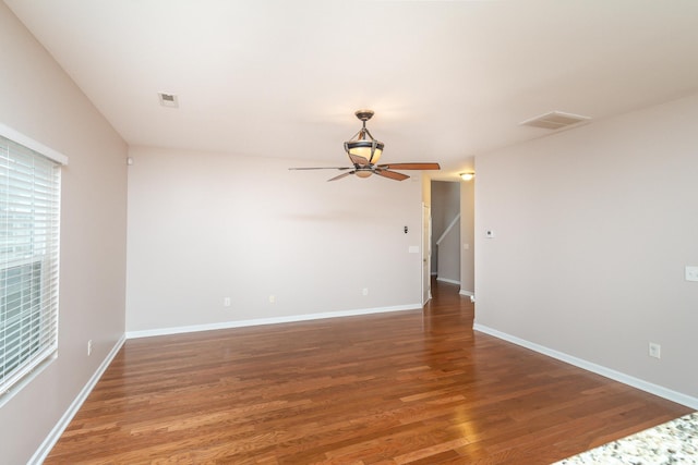 spare room featuring dark wood-type flooring and ceiling fan