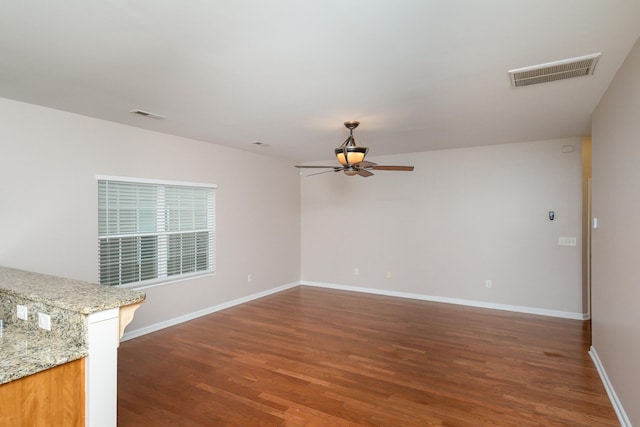 unfurnished room featuring ceiling fan and dark hardwood / wood-style flooring