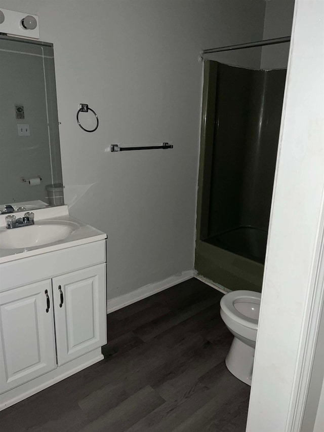 full bathroom with hardwood / wood-style flooring, vanity, shower / tub combination, and toilet