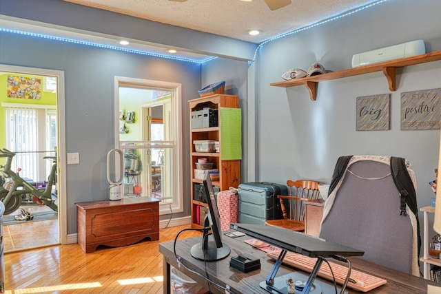 office area with light hardwood / wood-style flooring and a textured ceiling