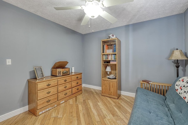 sitting room with ceiling fan, light hardwood / wood-style floors, and a textured ceiling