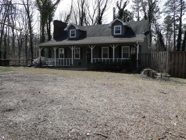 view of front of house featuring driveway, a porch, and fence