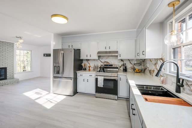 kitchen with white cabinets, pendant lighting, stainless steel appliances, and decorative backsplash