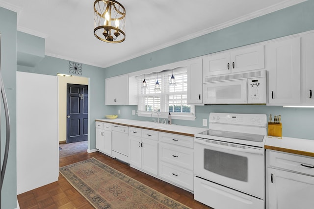 kitchen featuring white appliances, pendant lighting, and white cabinets