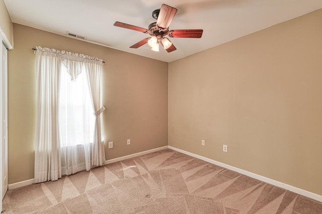 empty room featuring ceiling fan and light carpet