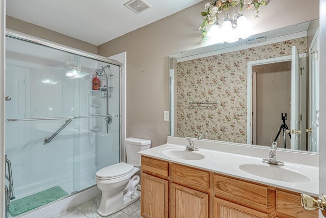 bathroom with vanity, toilet, and a shower with shower door