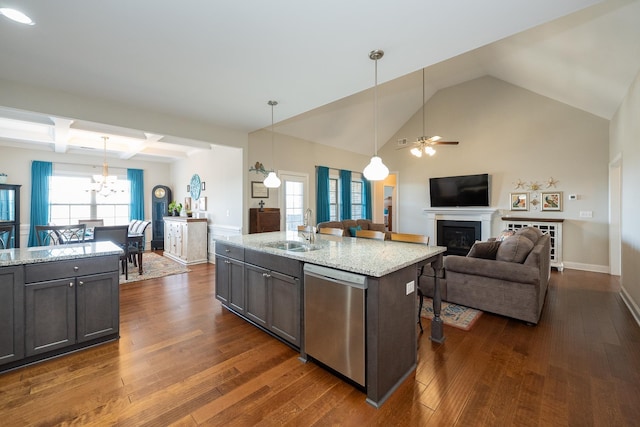 kitchen featuring hanging light fixtures, light stone countertops, sink, dishwasher, and dark hardwood / wood-style floors