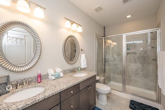 bathroom featuring toilet, vanity, tile patterned flooring, and a shower with shower door