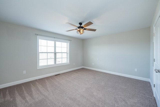carpeted spare room featuring ceiling fan