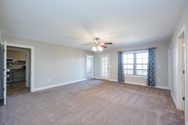 carpeted spare room with ceiling fan