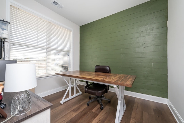 office space with dark wood-type flooring and wood walls