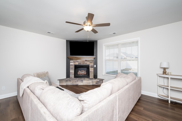 living room with dark hardwood / wood-style flooring, ceiling fan, and a fireplace