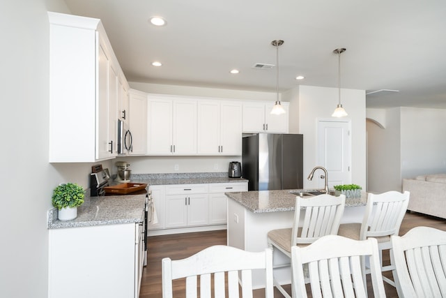 kitchen featuring appliances with stainless steel finishes, sink, hanging light fixtures, and light stone countertops