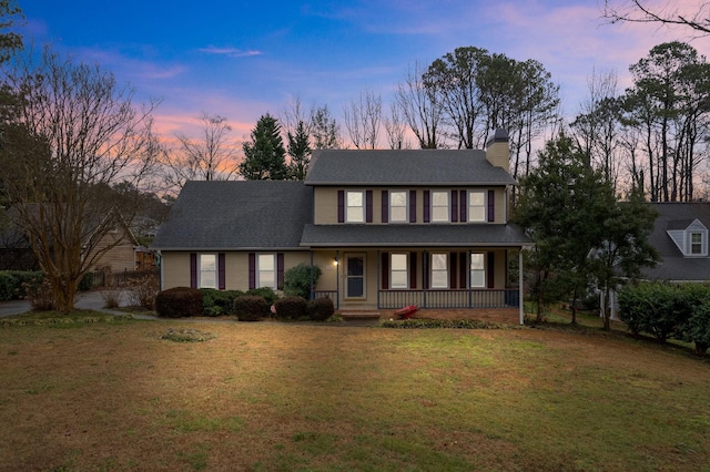 view of front of house featuring a lawn and covered porch