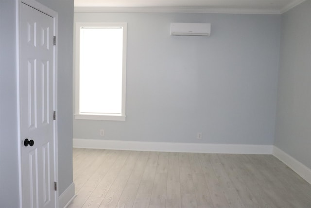 spare room with an AC wall unit, crown molding, and light wood-type flooring