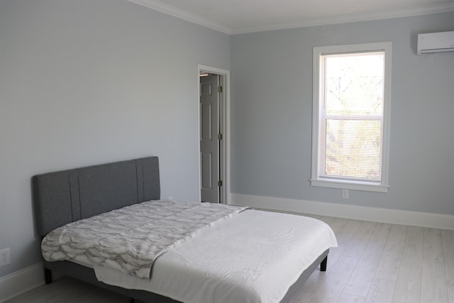 bedroom featuring a wall unit AC, ornamental molding, and light wood-type flooring