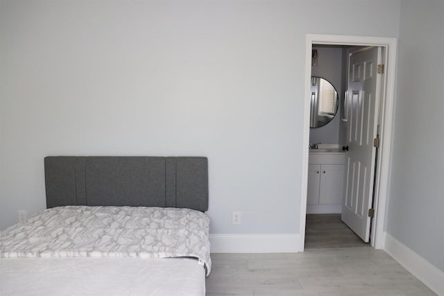 bedroom featuring sink and light hardwood / wood-style floors