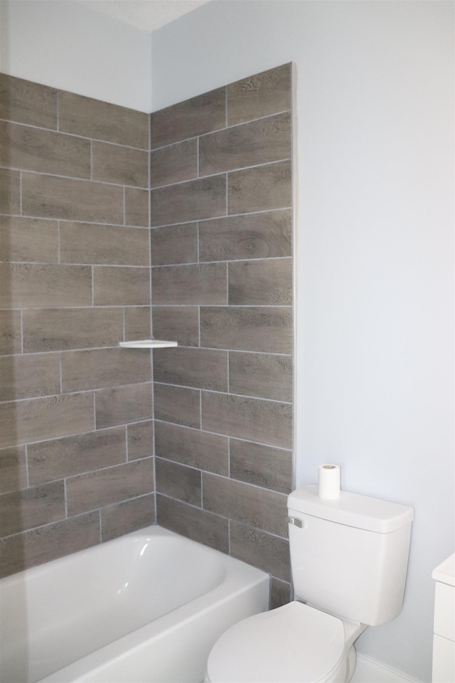 bathroom featuring toilet and tiled shower / bath