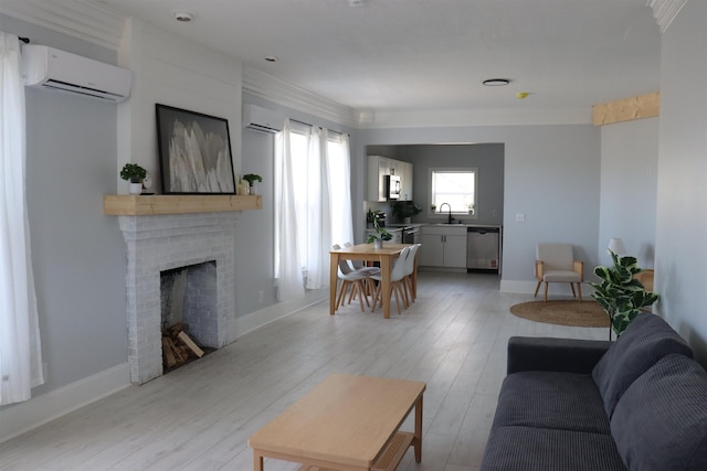 living room featuring sink, light hardwood / wood-style flooring, a wall unit AC, and a brick fireplace