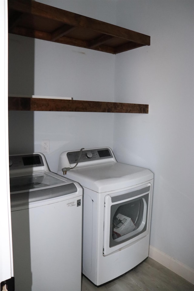 laundry area with independent washer and dryer and hardwood / wood-style floors