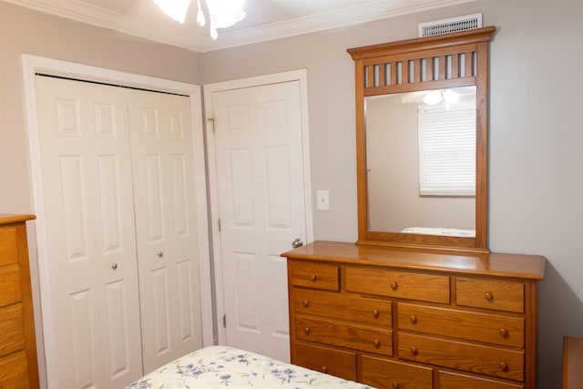 bedroom with crown molding and a closet