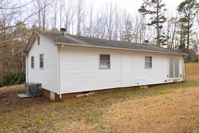 view of property exterior with a yard and central air condition unit