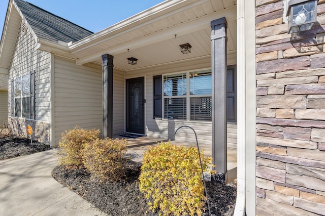 view of exterior entry featuring covered porch