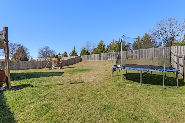 view of yard with a playground and a trampoline