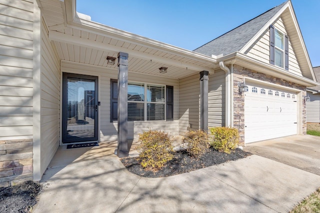 view of exterior entry featuring a porch and a garage