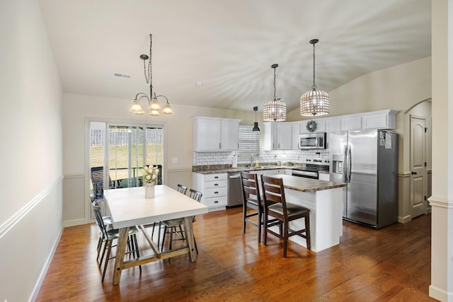 kitchen with stainless steel appliances, a center island, decorative light fixtures, sink, and white cabinets