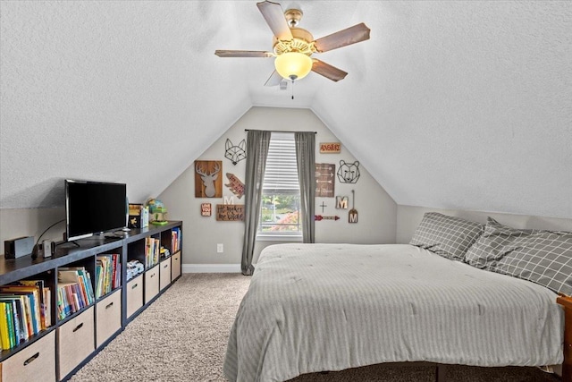 bedroom with ceiling fan, vaulted ceiling, light carpet, and a textured ceiling