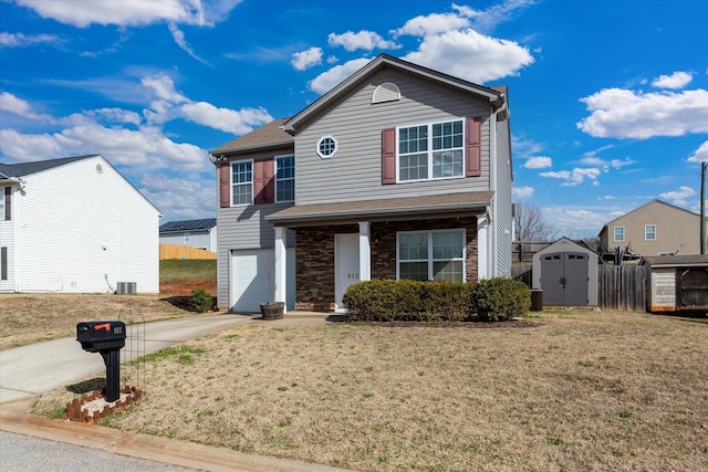 view of property with a storage unit, a front lawn, and a garage