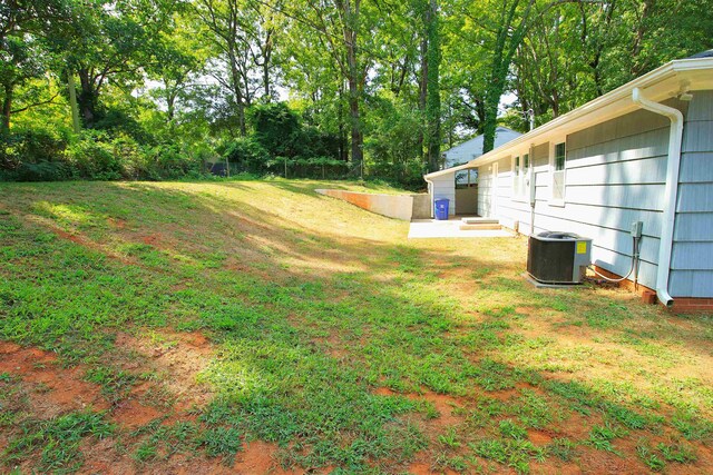 view of yard featuring central AC and fence