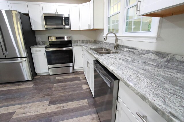 kitchen with a sink, white cabinetry, dark wood-style floors, and stainless steel appliances