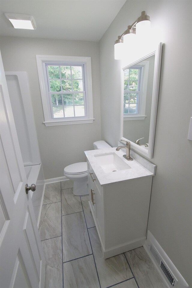 full bathroom featuring baseboards, vanity, toilet, and marble finish floor