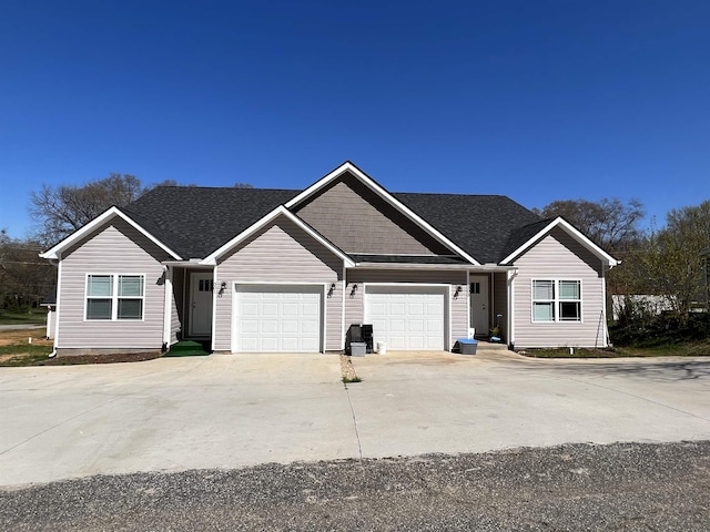 ranch-style house with an attached garage, a shingled roof, and concrete driveway