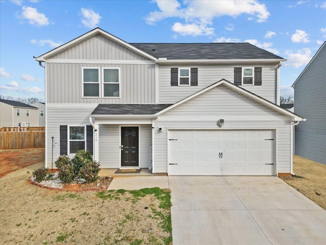 traditional-style home with a front yard, driveway, an attached garage, and fence